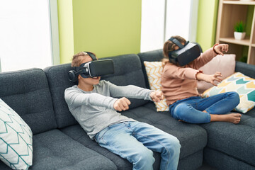 Two kids playing video game using virtual reality glasses at home