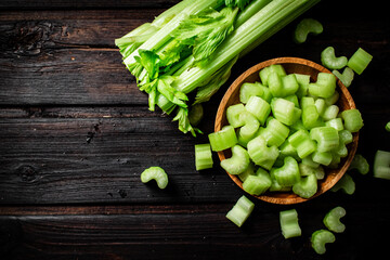 Sliced fresh celery. On a dark wooden background.