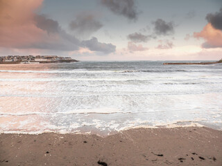 View on Kilkee beach and town houses in the background. County Clare, Ireland. Nobody. Popular summer resort. Atlantic ocean, Irish seascape. Cloudy sky.