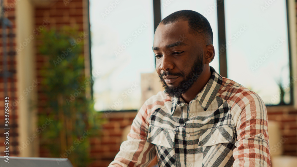Aufkleber young man typing online data on company laptop, doing remote work at home and using business network
