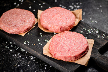 Raw burger on a cutting board. 