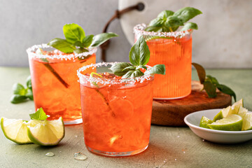 Strawberry basil margarita with lime wedges on the table