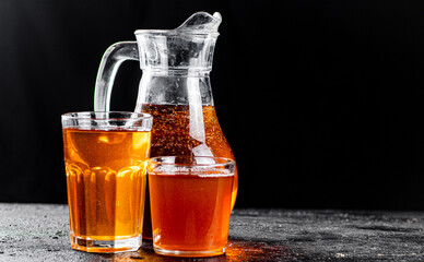 Apple juice in a jug and glasses with air bubbles. 