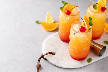 Rum punch in tiki glasses with orange slices and a cherry