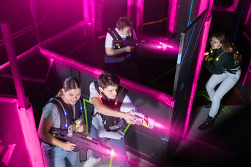 Team of young people play laser tag in a labyrinth. View from above
