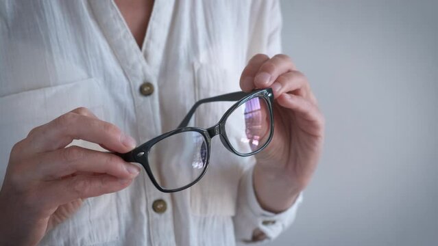 Use modern frame for glasses. A view of woman hand with modern glasses because of bad vision.