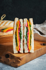 Two homemade sandwiches with sausage, cheese and arugula on a light concrete background