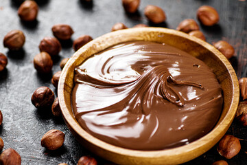 Hazelnut butter with peeled hazelnuts on the table. 
