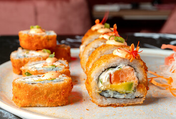 tempura sushi plate, stuffed with salmon, avocado and cream cheese. sushi in restaurant