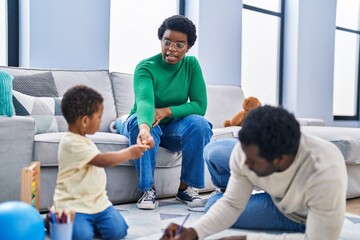 African american family drawing on notebook sitting on floor at home