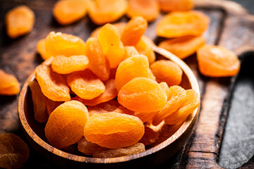 A bunch of dried apricots on a plate and on the table. 
