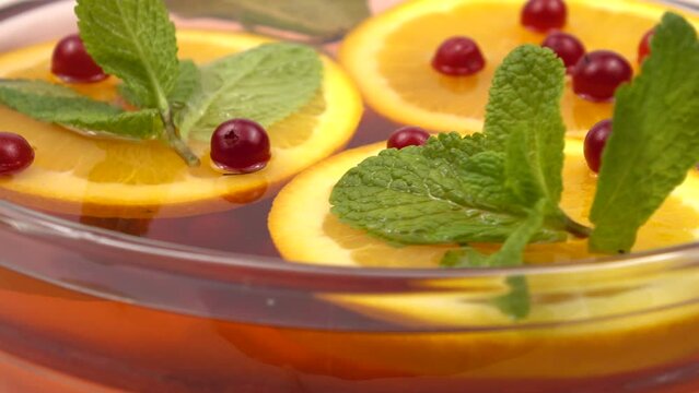 Berries of fresh cranberries, slices of orange   in a glass bowl with non-alcoholic fruit and berry punch, natural background