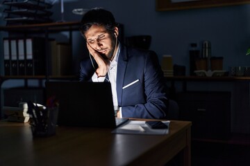 Handsome latin man working at the office at night thinking looking tired and bored with depression problems with crossed arms.