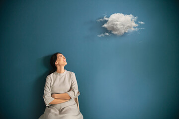 woman observes astonished surreal cloud flying in her room, abstract concept - obrazy, fototapety, plakaty