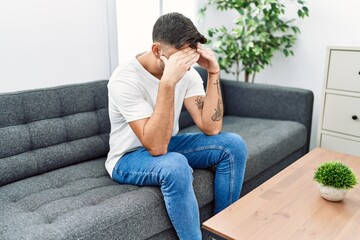 Handsome hispanic man sitting depressed at psychology consultation