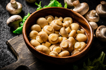 Delicious pickled mushrooms on a cutting board. 