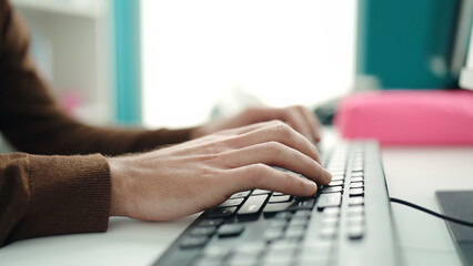 Young hispanic man using computer keyboard at home