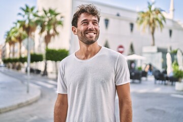 Young hispanic man smiling confident walking at street