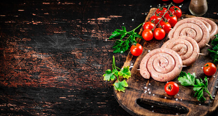 Round raw sausages with tomatoes and parsley. 