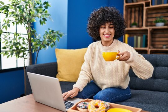 Young Middle East Woman Using Laptop Having Breakfast At Home