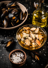 Pickled mussels in a glass bowl with spices. 
