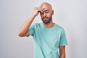 Middle age bald man standing over white background worried and stressed about a problem with hand on forehead, nervous and anxious for crisis
