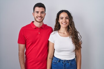 Obraz premium Young hispanic couple standing over isolated background with a happy and cool smile on face. lucky person.