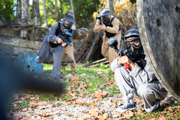 Group of people in full gear playing paintball on shooting range