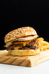 Burger cheese with potato in wooden table and black backgournd 