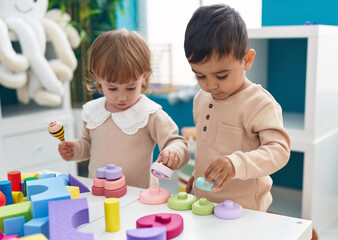 Fototapeta premium Two kids playing with construction blocks standing at kindergarten