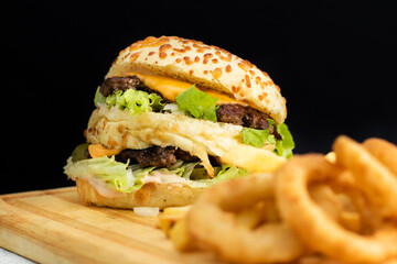Burger cheese with potato in wooden table and black backgournd 