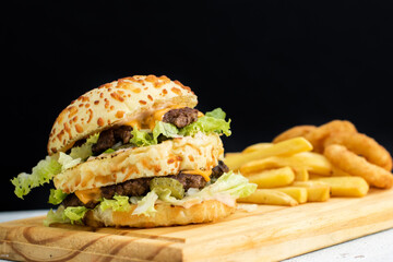 Burger cheese with potato in wooden table and black backgournd 