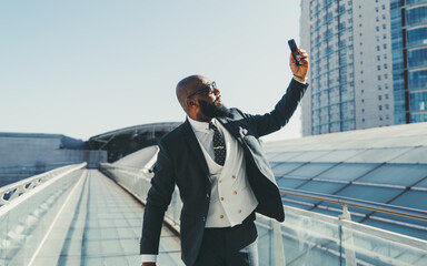 A capture of a black, bald, and unshaven businessman, looking gallant and damper in his elegant...