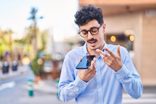 Young caucasian man talking on the smartphone with serious expression at street