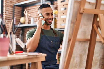 African american man artist talking on smartphone drawing at art studio