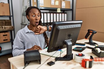 African woman working at small business ecommerce looking at the watch time worried, afraid of getting late