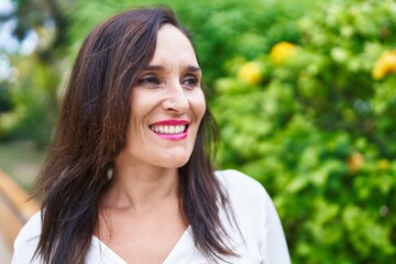 Young beautiful hispanic woman smiling confident looking to the side at park