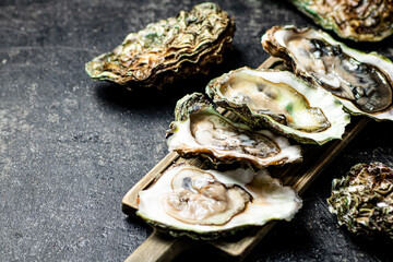 There are fresh oysters on the cutting board. 