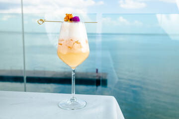 tropical cocktail with a sweet taste, restaurant cocktail on a white table with the background of the sea