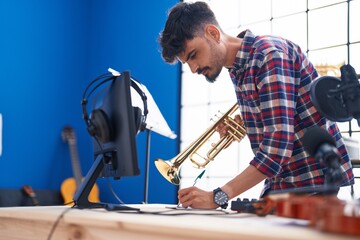 Young hispanic man composer holding trumpet at music studio © Krakenimages.com