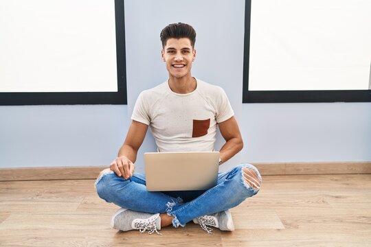 Young hispanic man using laptop at home with a happy and cool smile on face. lucky person.