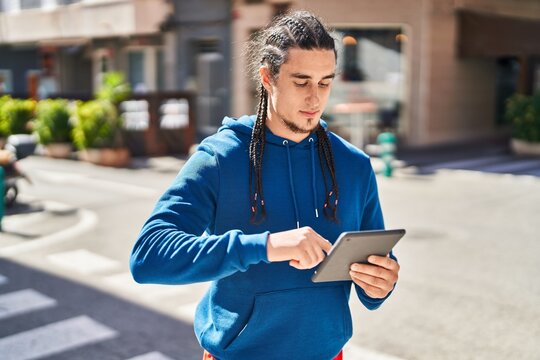 Young man using touchpad with serious expression at street