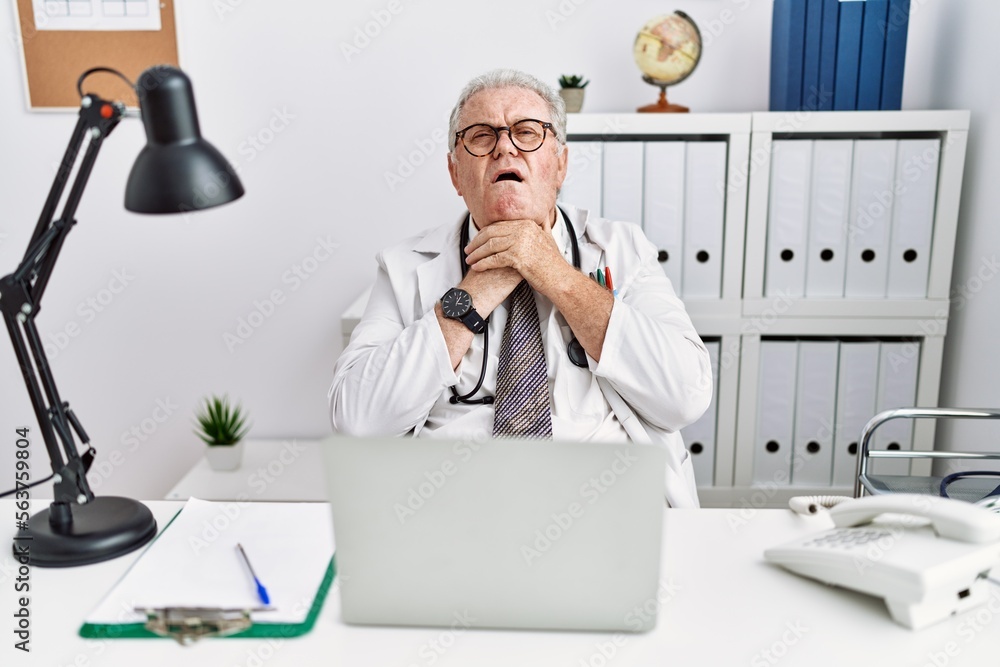 Canvas Prints Senior caucasian man wearing doctor uniform and stethoscope at the clinic shouting suffocate because painful strangle. health problem. asphyxiate and suicide concept.