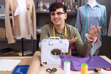 Non binary man tailor smiling confident speaking at atelier