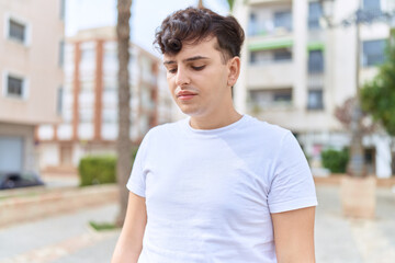 Non binary man looking to the side with worried expression at park