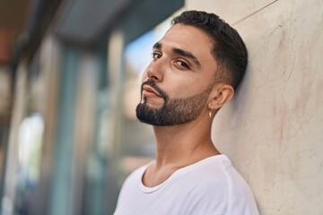 Young arab man looking to the side with serious expression at street