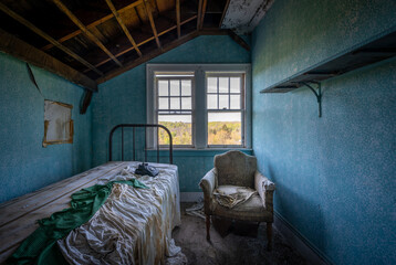 A small blue bedroom in an abandoned hotel