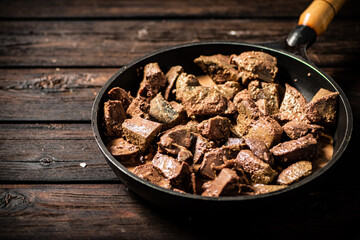 Liver fried in a frying pan. 
