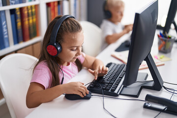 Two kids students using computer studying at classroom