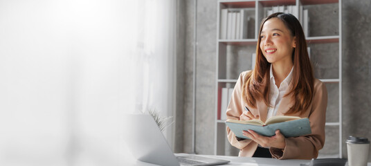 Young asia pretty entrepreneur busy woman in her private office working audit and calculating expense financial annual financial report balance sheet statement, checking inspection tax calculation